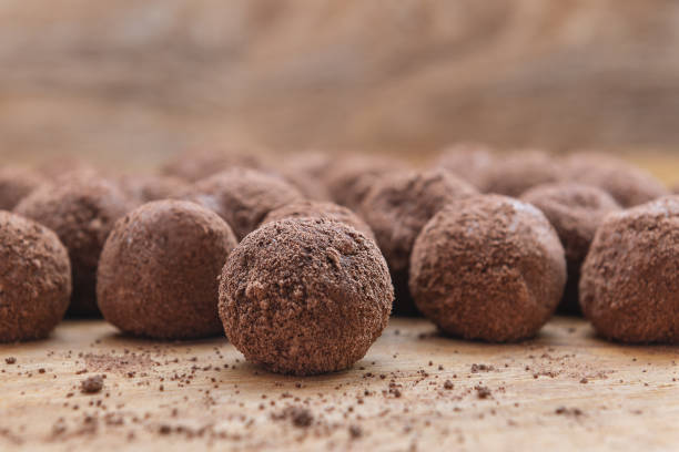 istock Chocolate candy and cocoa powder on wooden background 1146058932