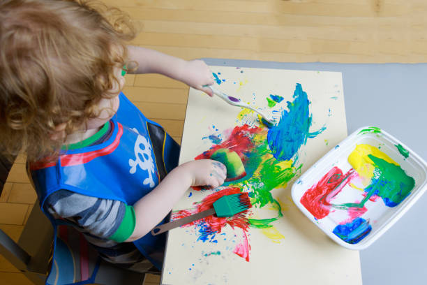 istock A young child plays with paint in this learning activity. 1146059492