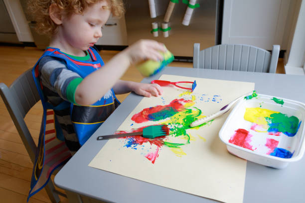 istock A young child plays with paint in this learning activity. 1146059495