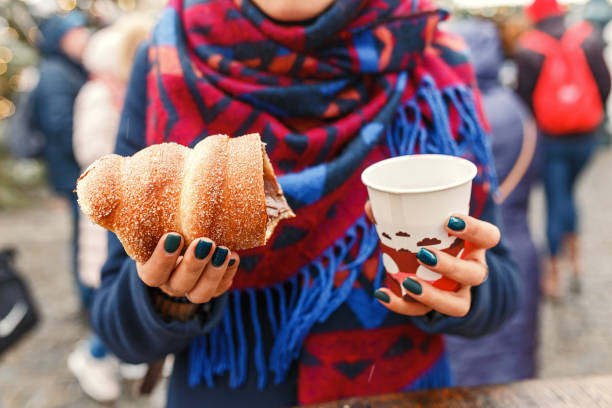 woman holding czech traditional delicious trdelnik and hot wine closeup - close to food and drink yummy food imagens e fotografias de stock