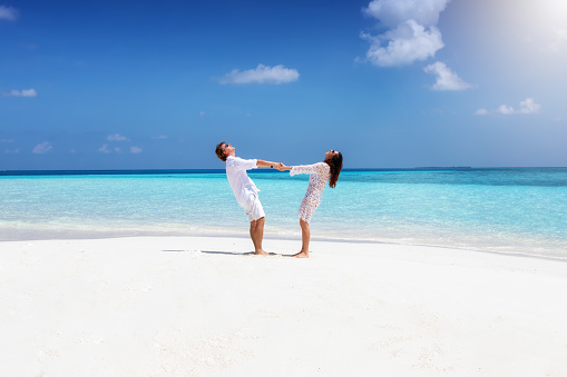 Happy couple is having fun on a tropical beach in the Maldives