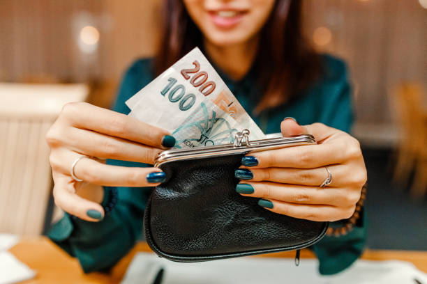 mujer cliente en el restaurante después de la cena obtiene dinero de su billetera para pagar la factura - czech culture currency wealth coin fotografías e imágenes de stock