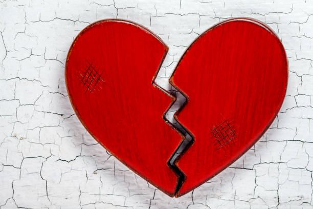istock Broken heart on cracked paint background 1146068835