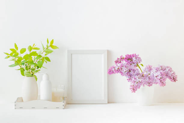 istock Home interior with decor elements. White frame, branches of lilac in a vase, interior decoration 1146069289