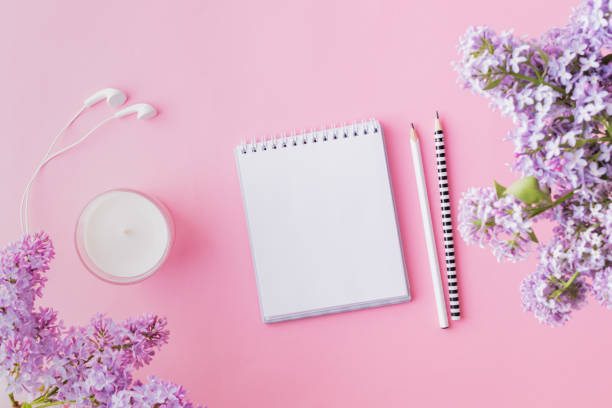istock Mockup white notebook with  branches of lilac on a pink background 1146069305
