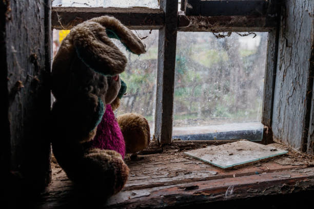 Vintage style teddy bears sitting on the windowsill watching people passing by