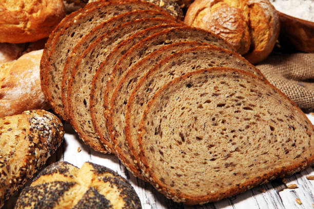 istock Assortment of baked bread and bread rolls on rustic white bakery table background 1146077231