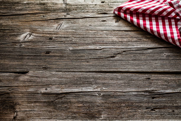 istock Empty rustic wooden table with gingham textile napkin at the top right corner. Copy space available. 1146077281