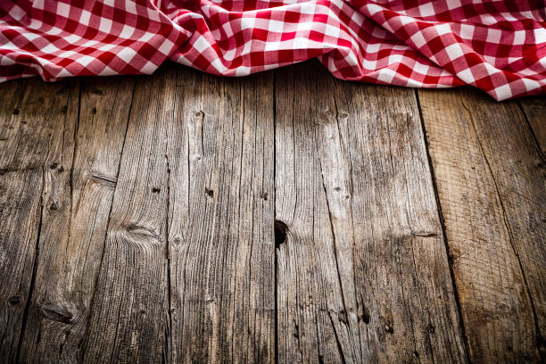 istock Empty rustic wooden table with gingham tablecloth at the top border. Copy space available. 1146077282