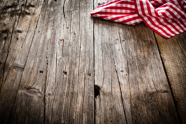 istock Empty rustic wooden table with gingham tablecloth at the top right corner. Copy space available. 1146077327