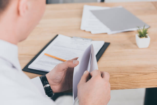 istock cropped view of businessman opening envelope at workspace, compensation concept 1146077513