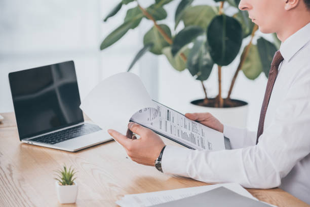 istock cropped view of businessman reading compensation claim at workplace 1146077536