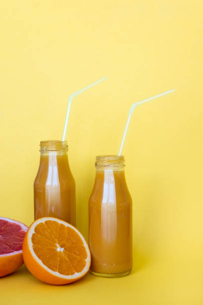istock Fresh orange juice with oranges on yellow background. Copy space 1146078795