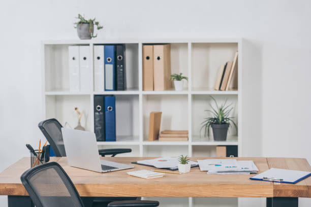 istock table in office with laptop, documents, chairs and bookcase fo folders on background 1146078873