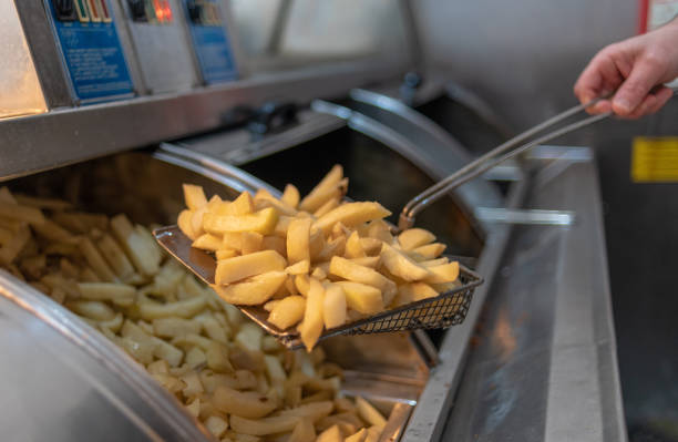 istock Potato chips coming out of a deep fat fryer 1146078880