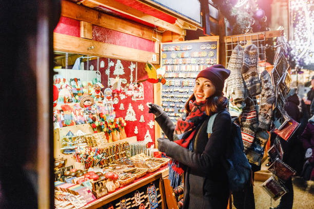 woman tourist buys souvenirs and gifts at the Christmas market in Prague woman tourist buys souvenirs and gifts at the Christmas market in Prague prague christmas market stock pictures, royalty-free photos & images