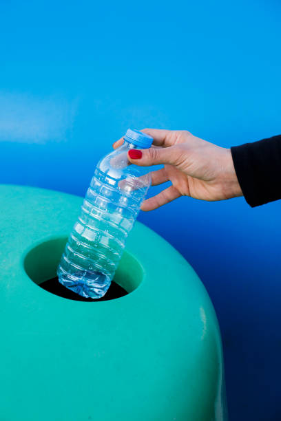 istock Hand placing bottles in recycling bin 1146082621