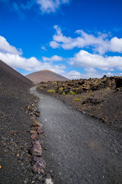 istock Spain, Lanzarote, Beautiful walking path alongside majestic volcano el cuervo through rough lava fields 1146082975