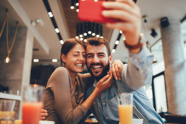 istock Young happy couple at cafe taking selfie 1146083328