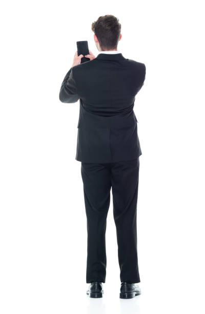 istock Young handsome businessman wearing a suit and tie - texting on smart phone 1146087601