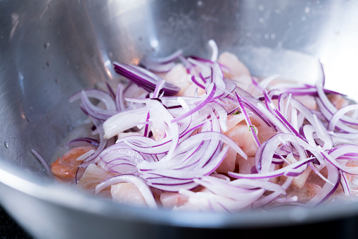 Onions and shrimp, in a bowl, ready to be prepared and served to the public