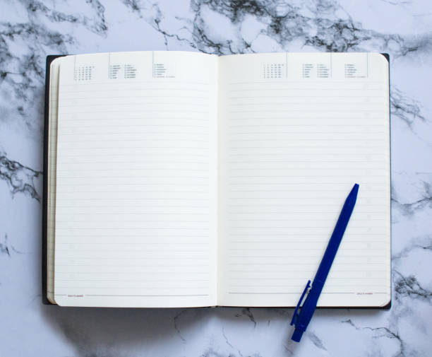 istock Blank page planner with blue pen on marble background 1146088908