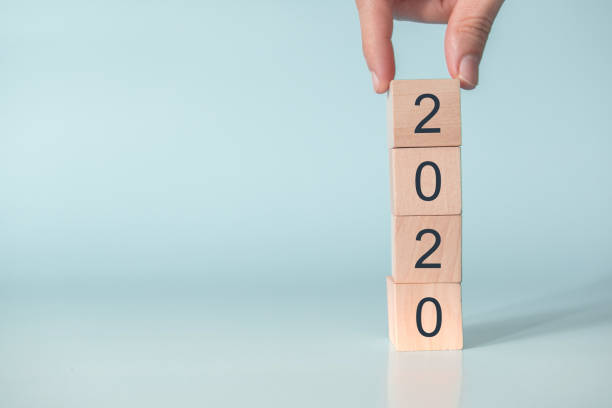 istock Hand of man putting wood cube shape with text new year 2020. 1146092805