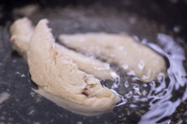 poaching filetes de frango em água fervente. fisiculturista/musculação dieta. tiro do close-up. - boiled - fotografias e filmes do acervo