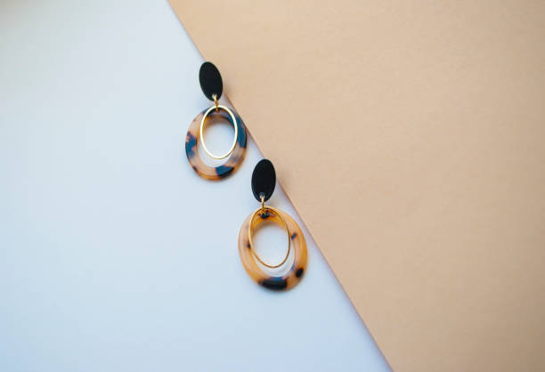 istock Earrings on beige and brown color background. 1146095493