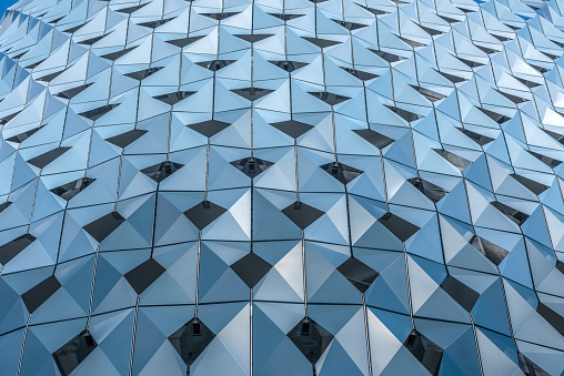 Abstract background with a triangular pattern of bluish. Coating on the wall of a public parking lot to provide shade and the passage of the breeze.