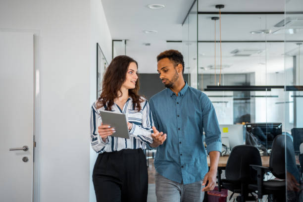 istock Business colleagues using a digital tablet and walking in the office 1146098095
