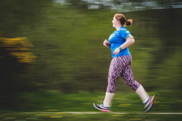Woman in 30s Running with motion panning blurred background