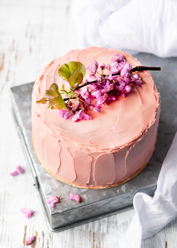 Romantic Pink cake decorated by flowers, rustic style for weddings, birthdays and events, mothers day on light background with copy space. Stylelife, spring.