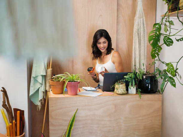 istock Female sales clerk scanning a pot while looking at the register computer 1146102575