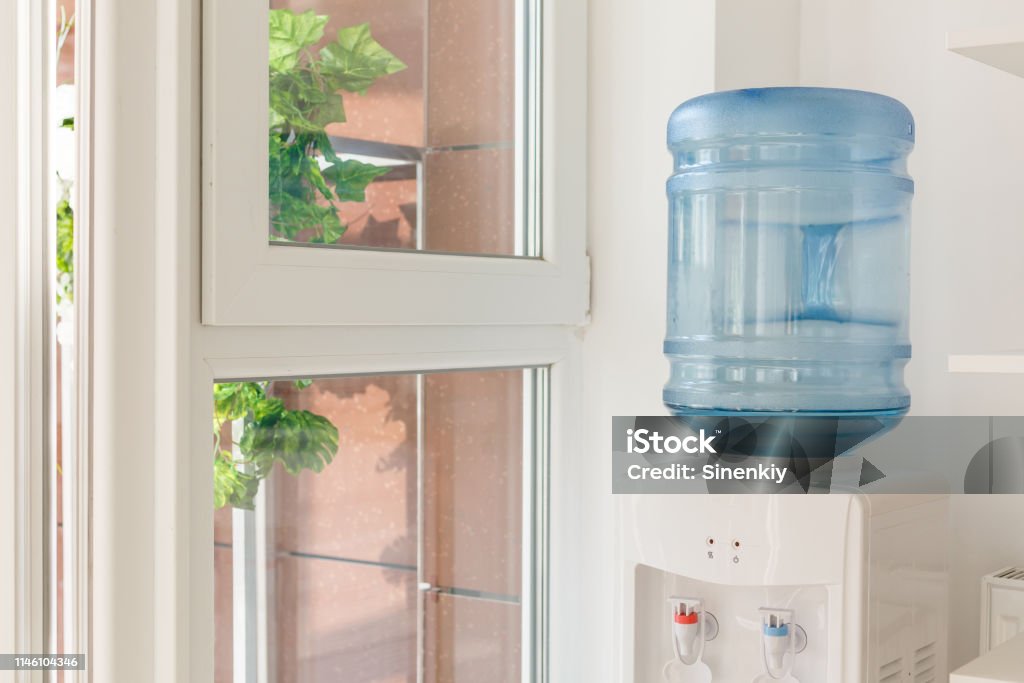 blaue Wasser-Gallone auf elektrischen Wasserkühler im Bürobereich - Lizenzfrei Trinkwasserbehälter Stock-Foto blaue Wasser-Gallone auf elektrischen Wasserkühler im Bürobereich - Lizenzfrei Trinkwasserbehälter Stock-Foto