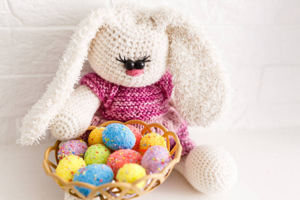 istock Funny little rabbit among Easter eggs in velour grass isolated on white 1146104618