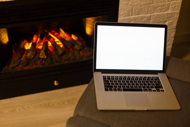 istock laptop with blank screen for copyspace on fireplace background 1146105719