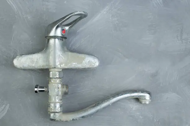 water-tap on the gray concrete wall . Copy space. Top view