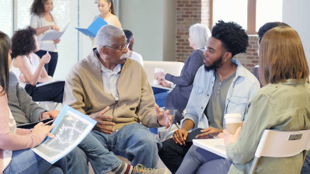 Mixed age group discusses racial issues A multi-ethnic, multi generational group openly discusses the racial issues dividing their community. community center stock pictures, royalty-free photos & images