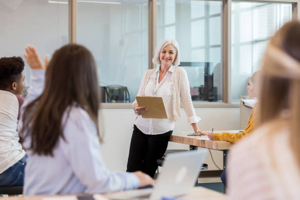 istock High school teacher smiles as student raises hand 1146107070