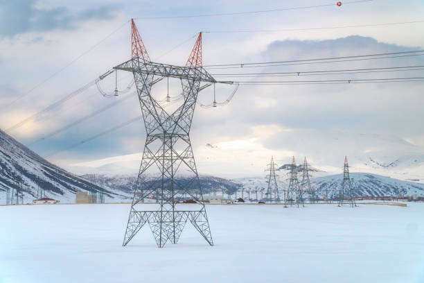 istock High voltage towers with blue sky and snowy mountains background 1146107825