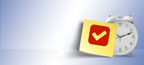 istock as a reminder, check  symbol on yellow sticky note paper with white alarm clock 1146107890