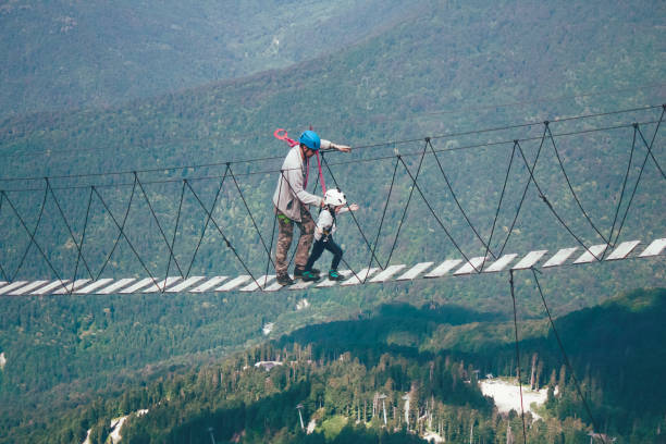 istock Man and boy walk along the rope bridge 1146108169