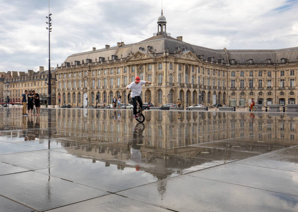 Bordeaux, France - September 9, 2018: The man performs acrobatics on a bicycle on Place de la Bourse, Bordeaux, France