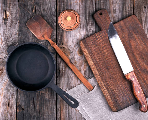 istock empty black round cast iron pan with handle, wooden cutting board 1146110483