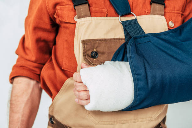 cropped view of repairman with broken arm and bandage on white background cropped view of repairman with broken arm and bandage on white background physical injury stock pictures, royalty-free photos & images
