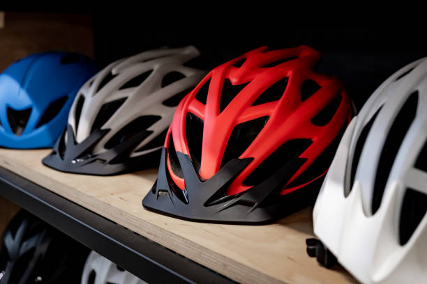 Modern bicycle helmets for family or group of people. Cycling and road safety concept - multicolored stylish helmets lying in a row red white blue bike stock pictures, royalty-free photos & images