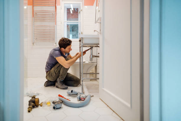 hombre joven solucionar una fuga debajo del lavabo del baño - cuarto de baño fotografías e imágenes de stock