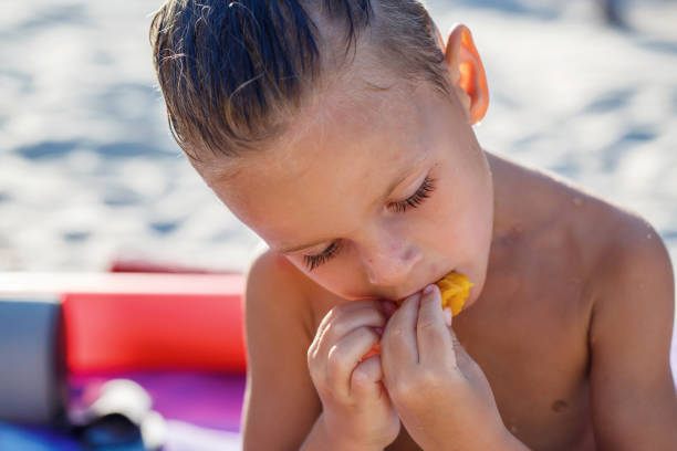 istock Child boy is eating fruits on the beach 1146120310