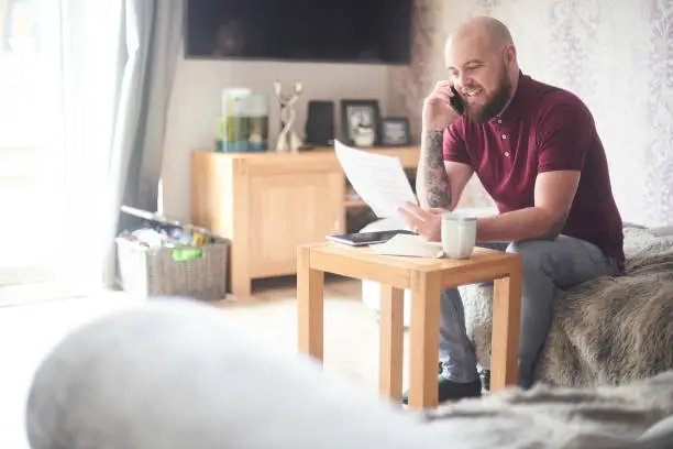 Photo of Smiling homeowner on the phone to customer services